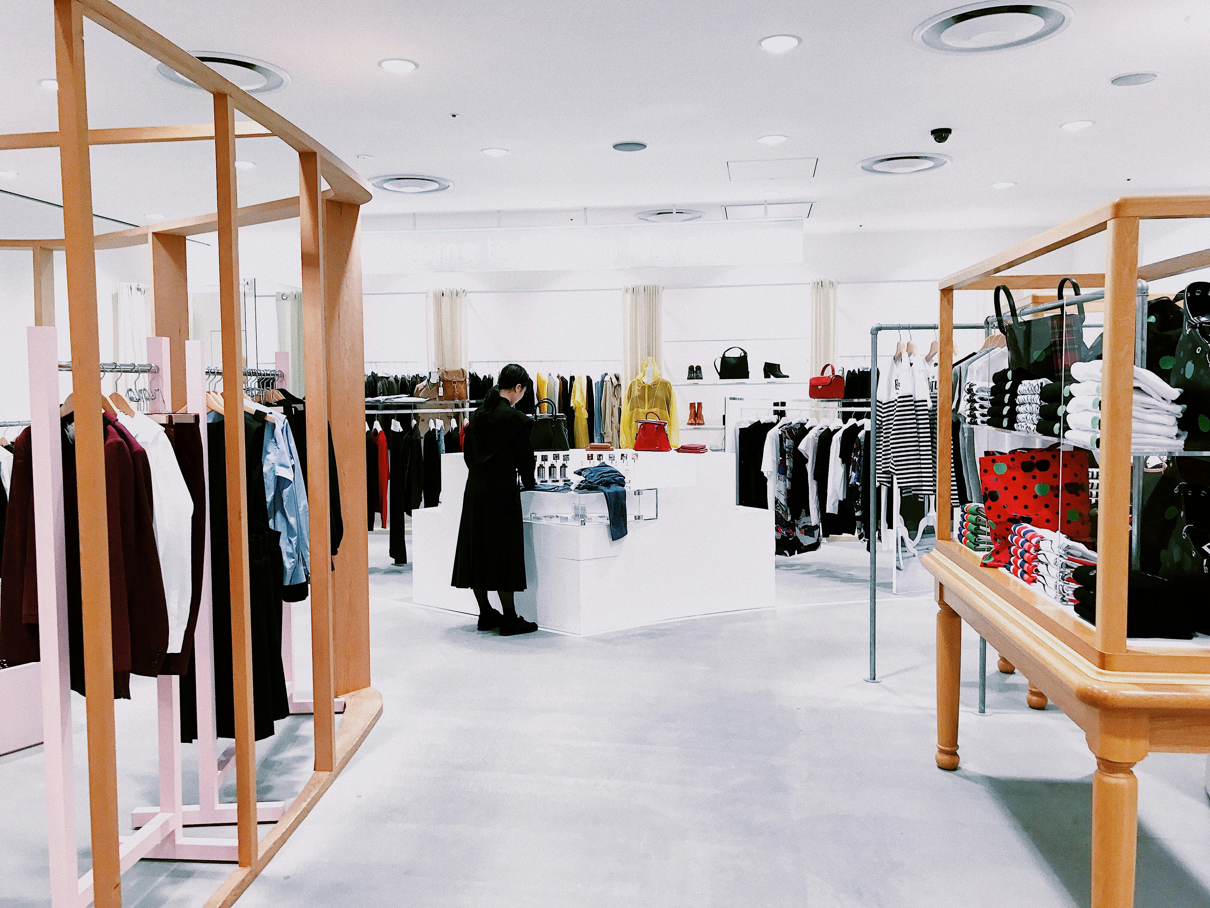 Interior of a modern retail clothing store with a shopper browsing the racks